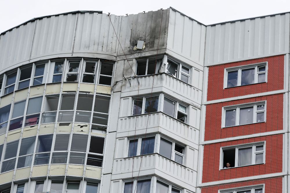 Seorang wanita melihat keluar jendela blok apartemen bertingkat yang rusak menyusul serangan drone yang dilaporkan di Moskow, Rusia, 30 Mei 2023. REUTERS/Maxim Shemetov