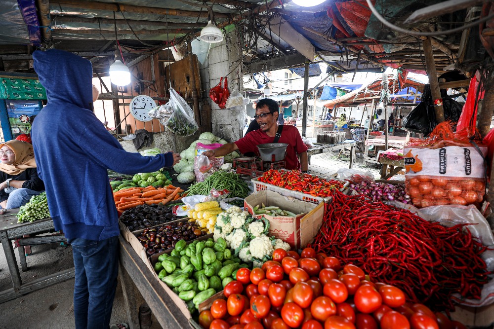 Pedagang melayani pembeli di salah satu pasar tradisional di Bogor, Jawa Barat, Selasa (14/3/2023). Inflasi menjadi momok bagi pedagang di pasar karena kenaikan harga tidak diikuti peningkatan daya beli. JIBI/Abdurachman