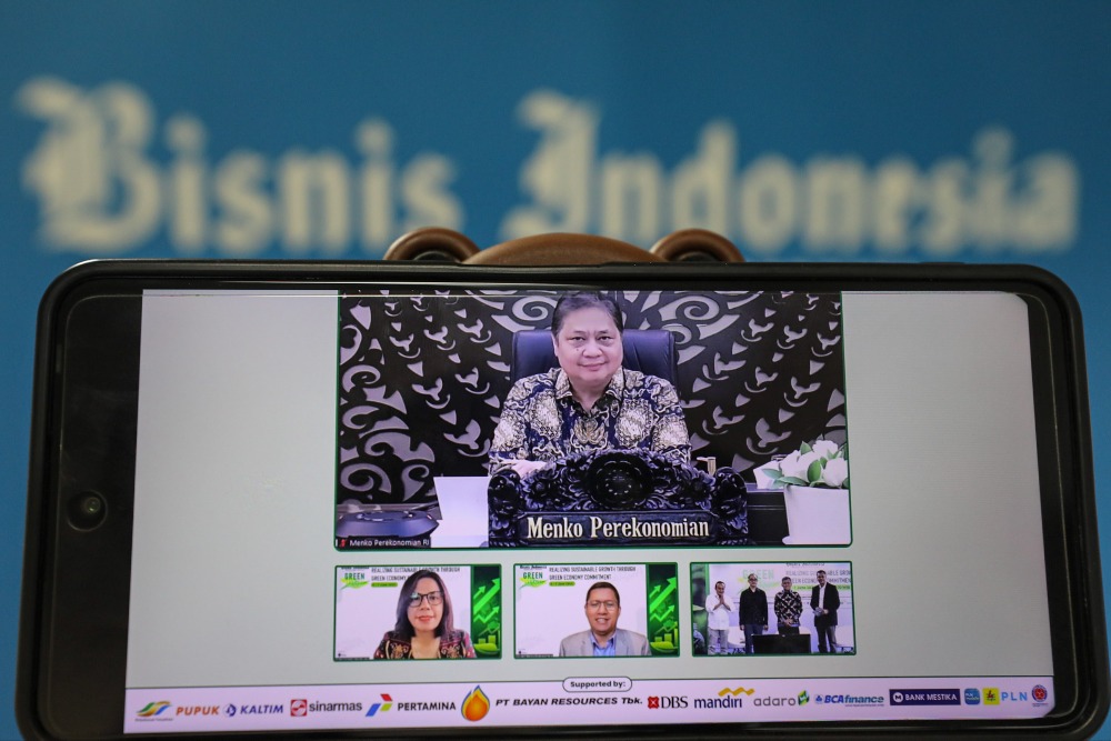 Layar menampilkan Menteri Koordinator Bidang Perekonomian Airlangga Hartarto (atas) secara virtual sebelum dimulainya diskusi panel Bisnis Indonesia Green Economy Forum 2023 hari kedua di Jakarta, Rabu (7/6).  JIBI/Bisnis/Arief Hermawan P