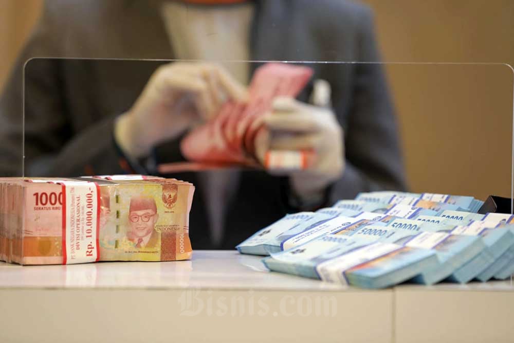 Pegawai merapikan uang Rupiah di kantor cabang BNI, Jakarta, Rabu (28/9/2022). Bisnis/Himawan L Nugraha