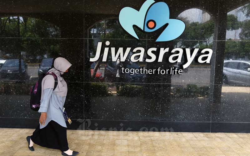 Warga melintasi logo Asuransi Jiwasraya di Jakarta, Senin (5/10/2020). Bisnis/Eusebio Chrysnamurti