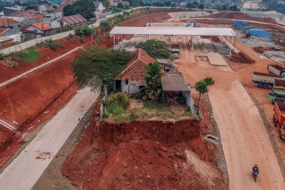 Foto udara rumah yang belum digusur pada proyek Jalan Tol Cijago seksi 3B yang menghubungkan wilayah Serpong,Cinere, dan Tol Jagorawi di Limo, Depok, Jawa Barat, Senin (24/7/2023). ANTARA FOTO/Yulius Satria Wijaya