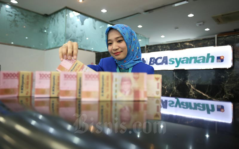 Karyawan menghitung uang rupiah di kantor cabang Bank BCA Syariah di Jakarta, Selasa (7/1/2020). Bisnis/Abdullah Azzam