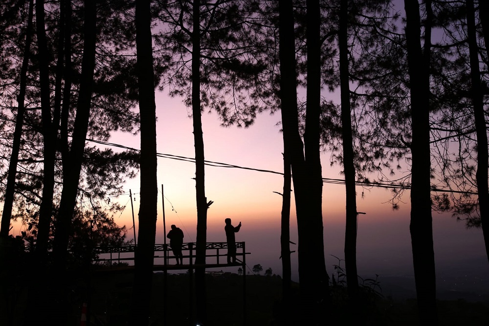 Wisatawan menikmati sunrise di Talaga Surian Camp Park/Bisnis-Rachman