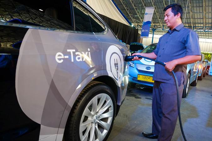 Pengemudi mengisi daya taksi listrik Bluebird di sela-sela peluncurannya di Jakarta, Senin (22/4/2019)./Bisnis-Felix Jody Kinarwan
