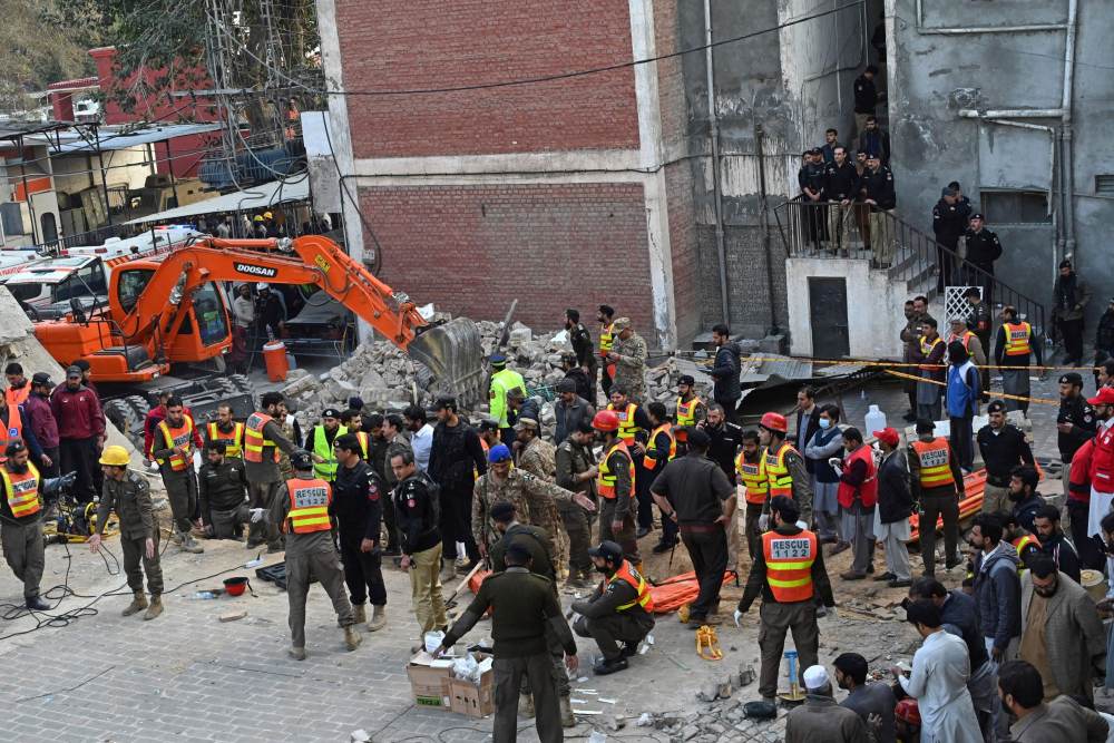 Petugas penyelamat di lokasi kejadian setelah ledakan bom bunuh diri di kompleks keamanan di Peshawar, Pakistan, pada 30 Januari 2023. Bloomberg/Fotografer: Abdul Majeed/Getty Images