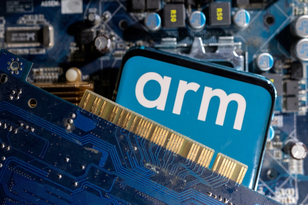 Smartphone dengan logo Arm Ltd yang dipajang di hadapan motherboard komputer, dalam ilustrasi yang diambil pada 6 Maret 2023. / Reuters-Dado Ruvic