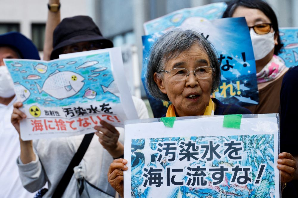Para pengunjuk rasa memegang tanda bertuliskan Jangan membuang air yang terkontaminasi radiasi ke laut, selama unjuk rasa menentang pembuangan air radioaktif yang telah diolah dari pembangkit listrik tenaga nuklir Fukushima Daiichi yang lumpuh akibat tsunami ke laut, di depan kediaman resmi Perdana Menteri Fumio Kishida. di Tokyo, Jepang, 25 Agustus 2023. REUTERS/Kim Kyung-Hoon