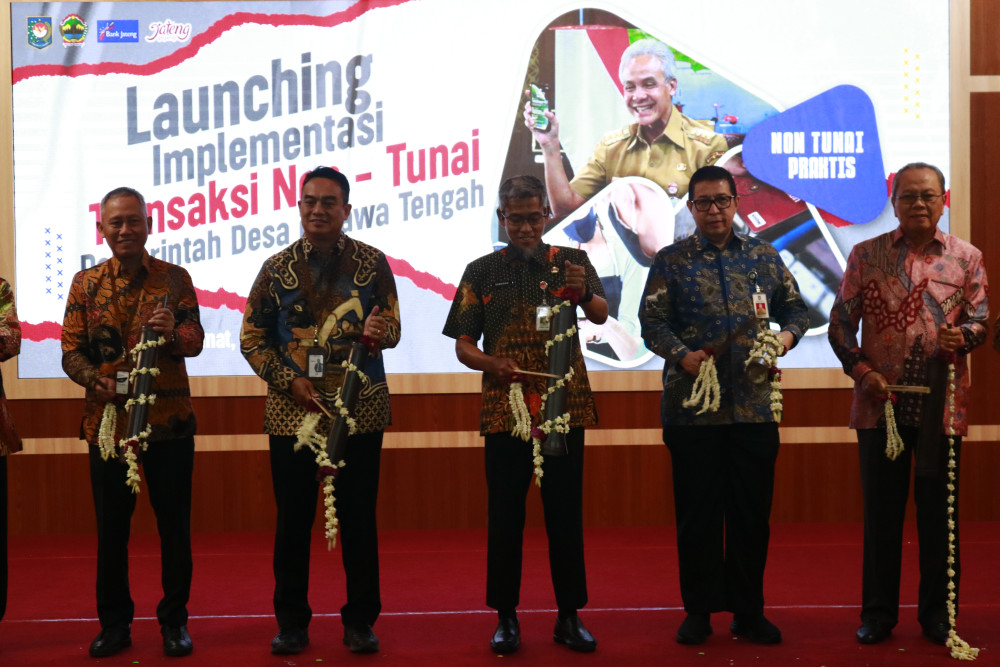 Pemukulan kentongan sembagai simbol diluncurkannya implementasi transaksi keuangan nontunai pemerintah desa se-Jawa Tengah pada Jumat (25/8/2023)./Bisnis-Muhammad Faisal Nur Ikhsan.