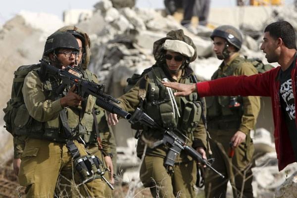 Seorang pria Palestina berdebat dengan tentara Israel ketika penghancuran rumah seorang Palestina atas perintah pasukan Israel saat ia mencoba menghentikan penghancuran tersebut di desa Biet Ula Tepi Barat, barat Hebron, Kamis (21/1)./Reuters