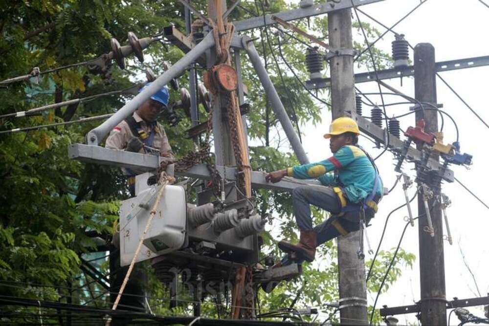 Tehnisi PLN mengerjalan penggantian load break switch yang berfungsi pemutus dan penyambung jaringan listrik yang dapat dikendalikan jarak jauh di Makassar, Sulawesi Selatan, Selasa (16/5/2023)./Bisnis-Paulus Tandi Bone.