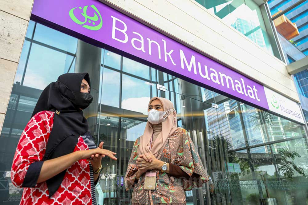 Karyawati beraktivitas di depan kantor cabang PT Bank Muamalat Indonesia Tbk. di Jakarta, Selasa (12/7/2022). Bisnis/Abdurachman