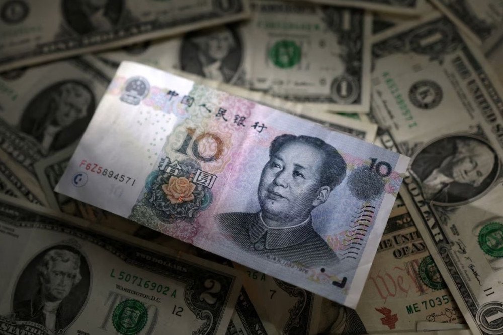 Ilustrasi uang kertas Yuan dan dolar AS. REUTERS/Dado Ruvic