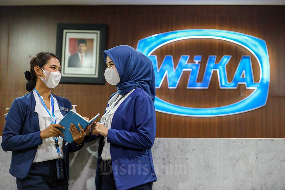 Karyawati beraktivitas di depan logo PT Wijaya Karya (Persero) Tbk. (WIKA) di Jakarta, Senin (11/7/2022). Bisnis/Abdurachman