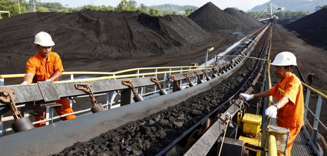 Pekerja melakukan inspeksi pengangkutan batu bara di atas ban berjalan./Bloomberg - Dadang Tri