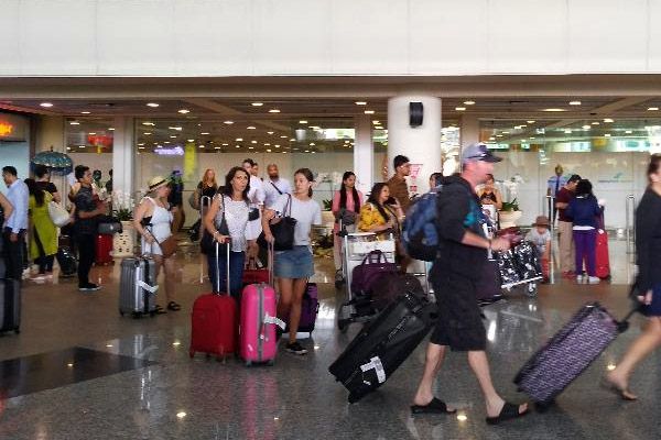 Sejumlah wisatawan keluar dari pintu kedatangan terminal internasional Bandara Ngurah Rai./Bisnis