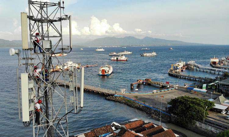 Teknisi XL Axiata melakukan pemeliharaan perangkat BTS di atas tower yang berlokasi di kawasan Pelabuhan Penyeberangan Ketapang, Banyuwangi, Jawa Timur, Kamis (14/3/2019)./Bisnis-Abdullah Azzam