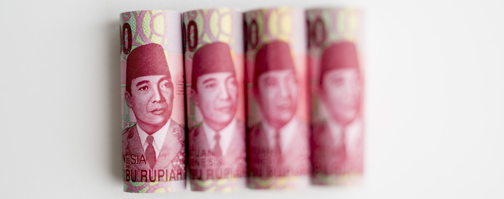 Potret wajah Mantan Presiden Sukarno dalam uang lembar Rp100.000 yang berjejer. - Bloomberg/Brent Lewin