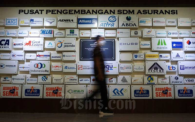 Karyawan beraktivitas di dekat logo-logo perusahaan asuransi di kantor Asosiasi Asuransi Umum Indonesia (AAUI) di Jakarta, beberapa waktu lalu. Bisnis/Suselo Jati