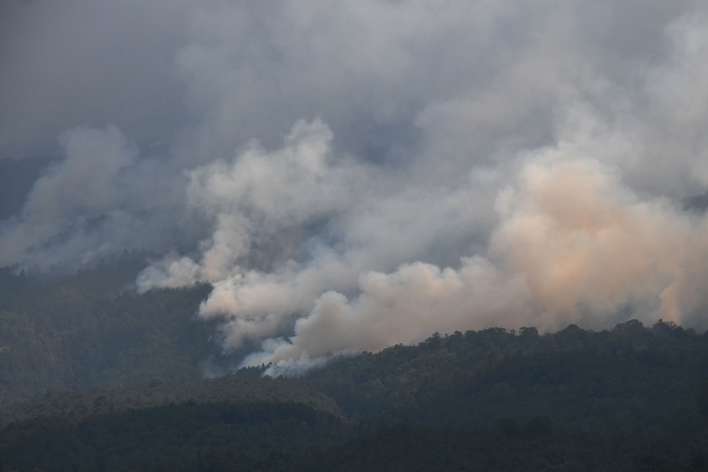 Asap mengepul dari lokasi kebakaran hutan Gunung Lawu terlihat dari Karanggubito, Kendal, Ngawi, Jawa Timur, Senin (2/10/2023). Menurut data di Posko Penanganan Darurat Karhutla Gunung Lawu 2023 luas keseluruhan hutan dan lahan yang terbakar di Gunung Lawu sejak 30 Agustus hingga Senin (2/10) sore mencapai 1.100 hektare, dan dari luas tersebut yang terbakar sejak Jumat (29/9) seluas 400 hektare./Antara-Siswowidodo.