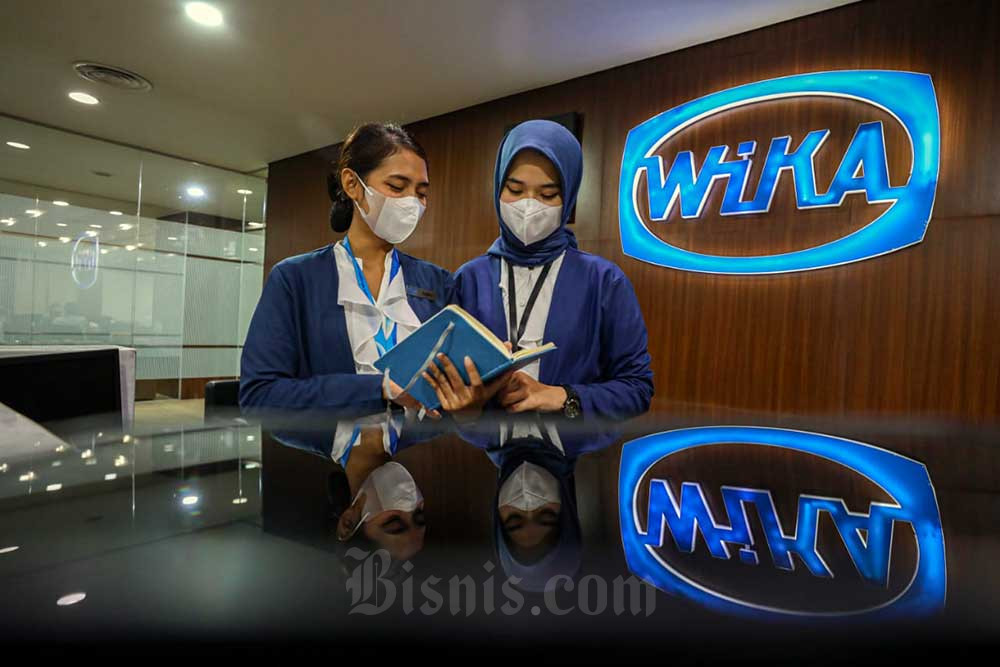 Karyawati beraktivitas di depan logo PT Wijaya Karya (Persero) Tbk. (WIKA) di Jakarta, Senin (11/7/2022). Bisnis/Abdurachman