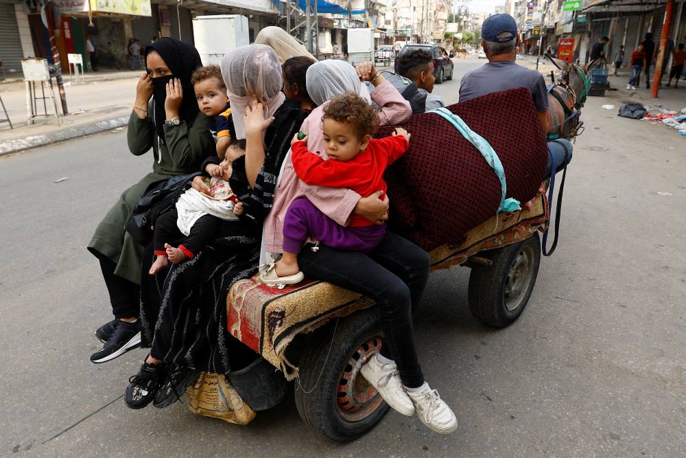 Warga Palestina meninggalkan rumah mereka di tengah serangan Israel di Khan Younis, Jalur Gaza selatan, 10 Oktober 2023. REUTERS/Ibraheem Abu Mustafa