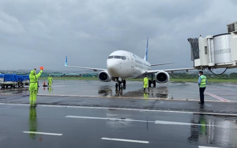 Petugas di Bandara Internasional Ahmad Yani sedang memandu pesawat yang hendak parrkir di tengah hujan lebat./Istimewa