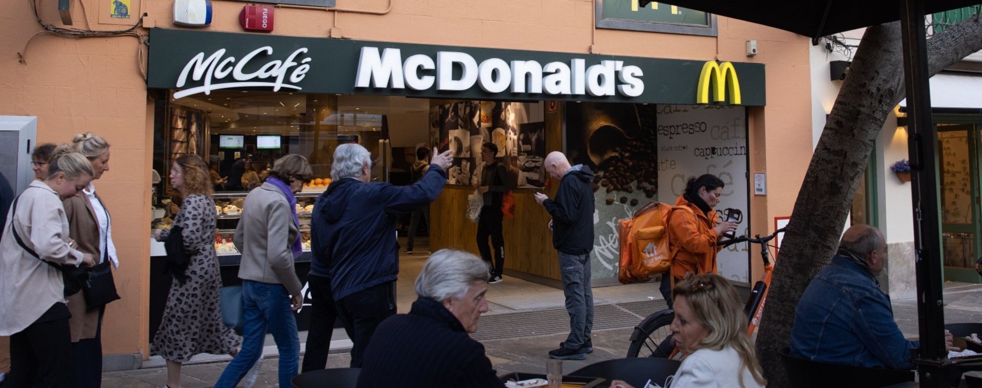 Pengunjung berada di luar gerai McDonalds yang berada di Mallorca, Spanyol pada Kamis (30/3/2023). - Bloomberg/Andrey Rudakov