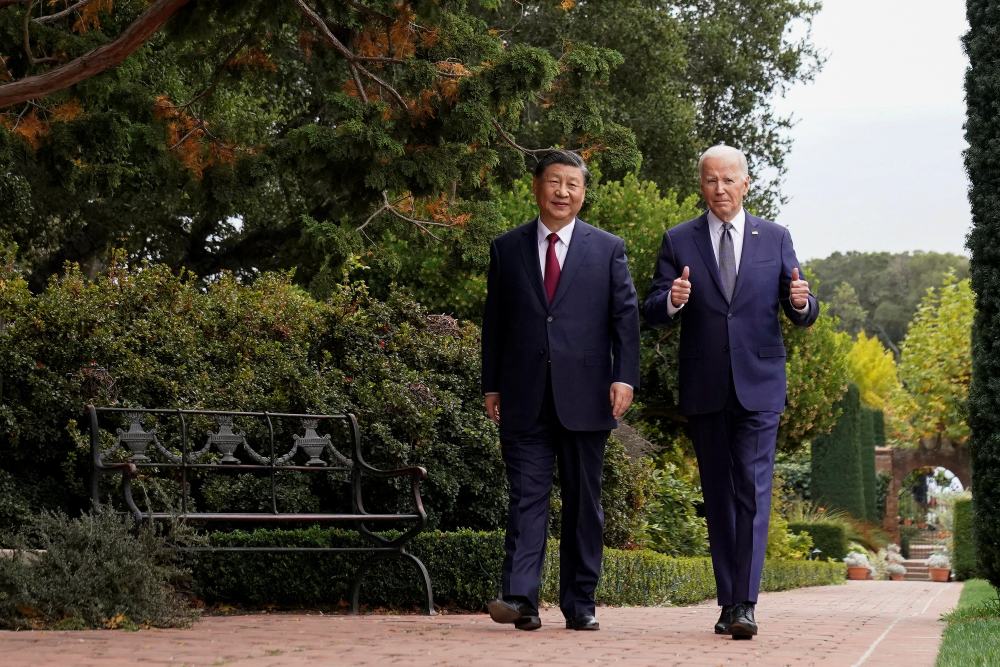 Presiden Amerika Serikat (AS) Joe Biden mengacungkan jempol saat berjalan bersama Presiden China Xi Jinping di perkebunan Filoli di sela-sela KTT Kerja Sama Ekonomi Asia-Pasifik (APEC), di Woodside, California, AS, 15 November 2023. REUTERS/Kevin Lamarque