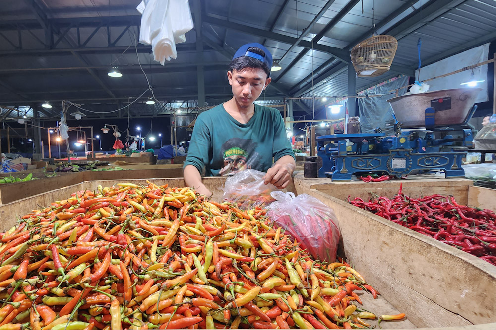Aktivitas seorang pedagang cabai rawit dan cabai merah besar di Pasar Induk Sidotopo - Surabaya, Kamis (23/11/2023)./Bisnis-Peni Widarti