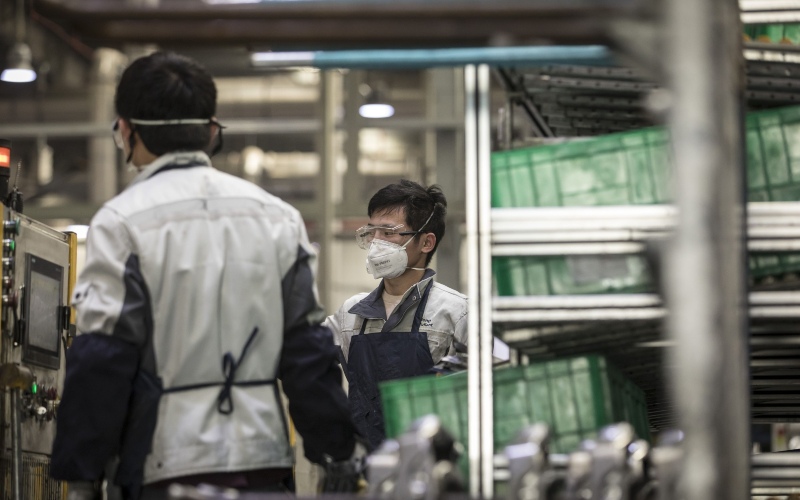 Pekerja mengenakan masker di pabrik milik Yanfeng Adient Seating Co. di Shanghai, China, Senin (24/2/2020)./Bloomberg-Qilai Shen