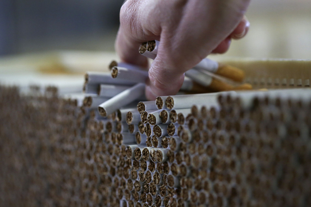 Pekerja memeriksa rokok yang diproduksi di pabrik di Inggris. - Bloomberg/Chris Ratcliffe