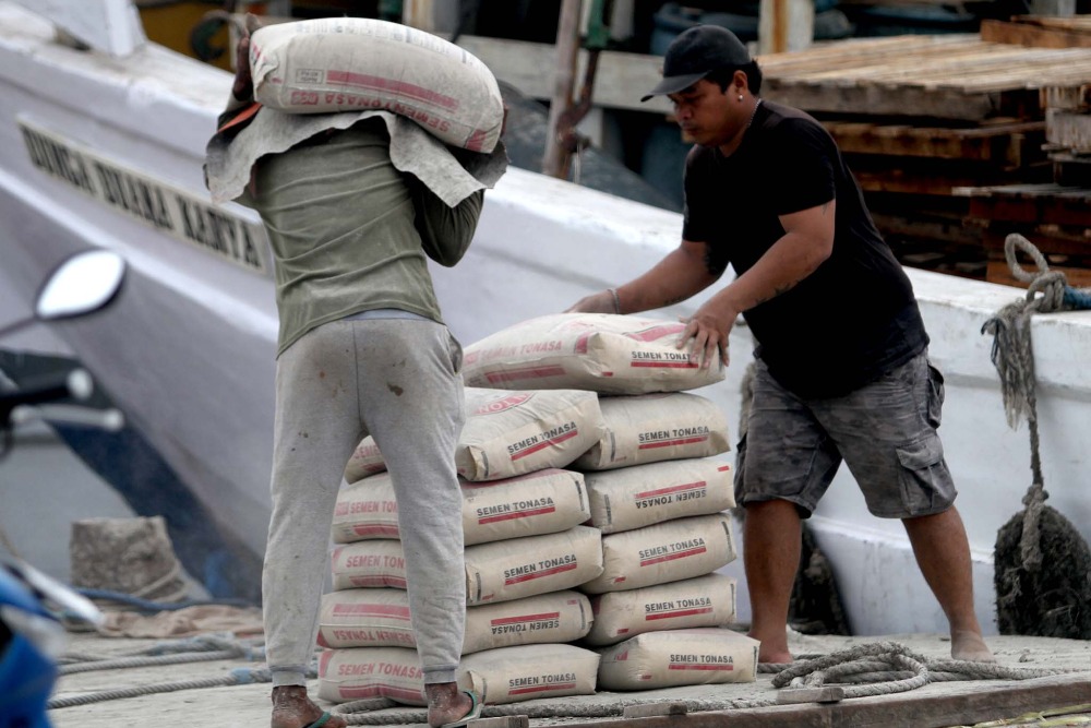 Pekerja memindahkan semen milik Semen Tonasa (Semen Indonesia Group) di Pelabuhan Paotere Makassar, Sulawesi Selatan, Selasa (14/11/2023). Bisnis/Paulus Tandi Bone