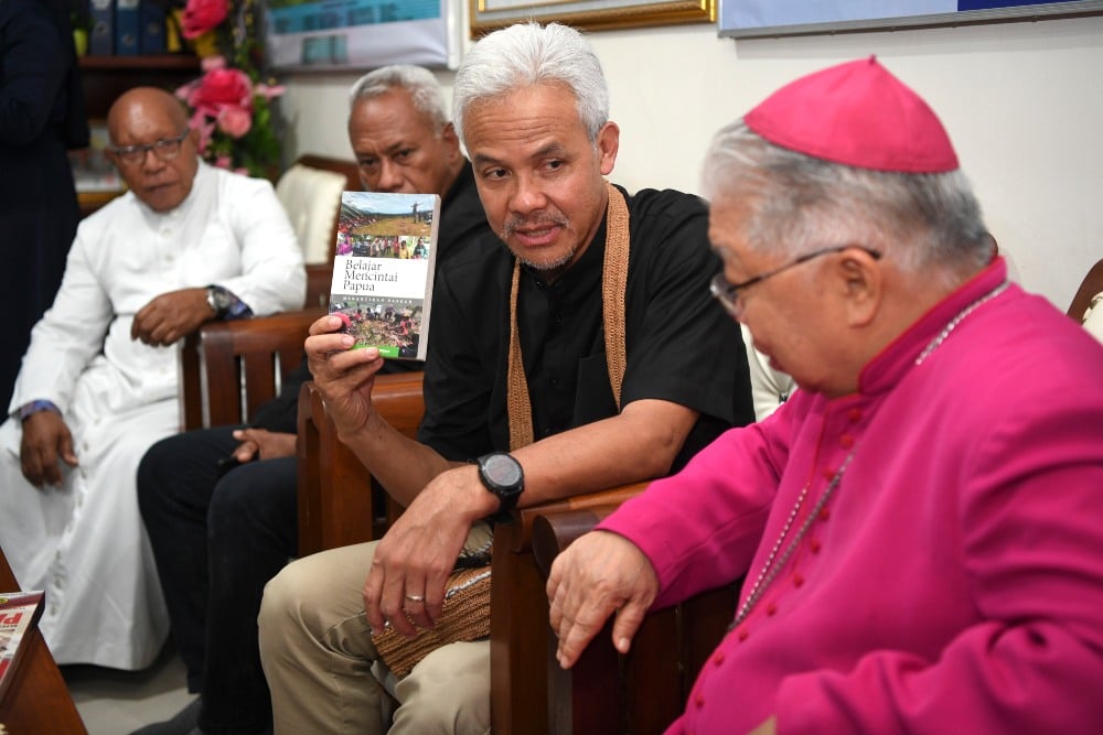Calon Presiden nomor urut 3 Ganjar Pranowo (kedua kanan) menunjukkan buku yang diberi oleh Uskup Agung Merauke Mgr. Petrus Canisius Mandagi (kanan) saat berkunjung ke Keuskupan Agung Merauke, Papua Selatan, Selasa (28/11/2023). Dalam kampanye perdananya tersebut, Ganjar Pranowo melakukan silaturahim dengan sejumlah pemuka agama Khatolik di Merauke. ANTARA FOTO/M Risyal Hidayat/nym.