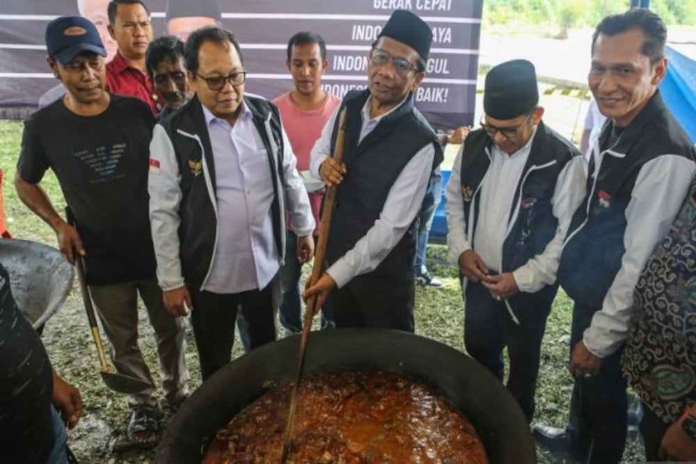 Cawapres nomor urut 3 Mahfud MD (tengah) melihat pembuatan makanan khas Desa Jaboi saat berkampanye di Desa Jaboi, Kota Sabang, Aceh, Selasa (28/11/2023). (ANTARA FOTO/Asprilla Dwi Adha/nym)