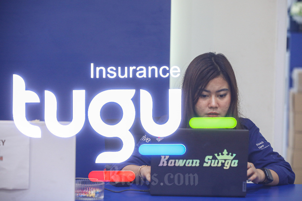 Karyawati beraktivitas di dekat logo Tugu Insurance, Jakarta, Senin (18/9/2023). Bisnis/Abdurachman