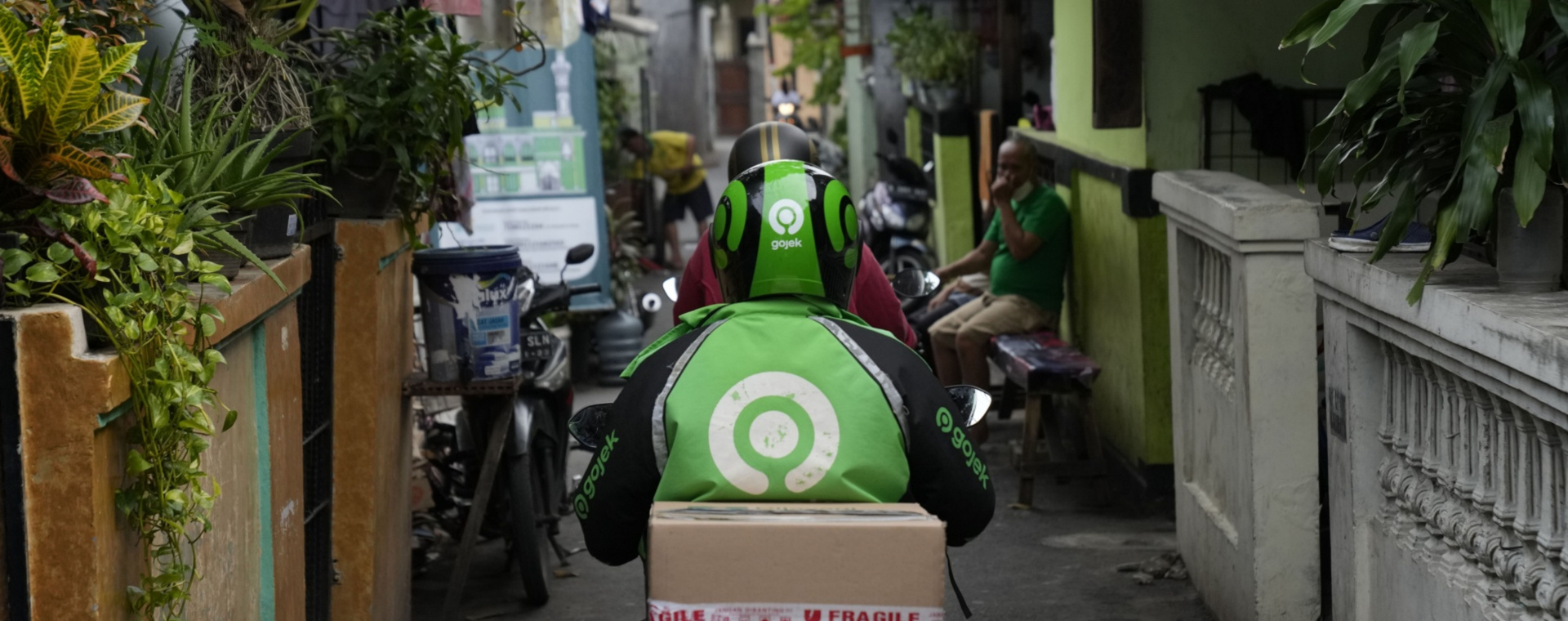 Pengemudi atau driver Gojek mengantarkan paket pesanan dari platform Tokopedia di Jakarta, Jumat (8/4/2022). - Bloomberg/Dimas Ardian