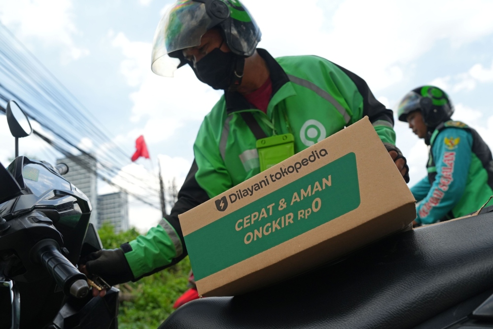Seorang pengemudi pengiriman Gojek mengambil pesanan PT Tokopedia di pusat pemenuhan di Jakarta, Indonesia, pada Senin, 12 Desember 2022. - Bloomberg/Dimas Ardian