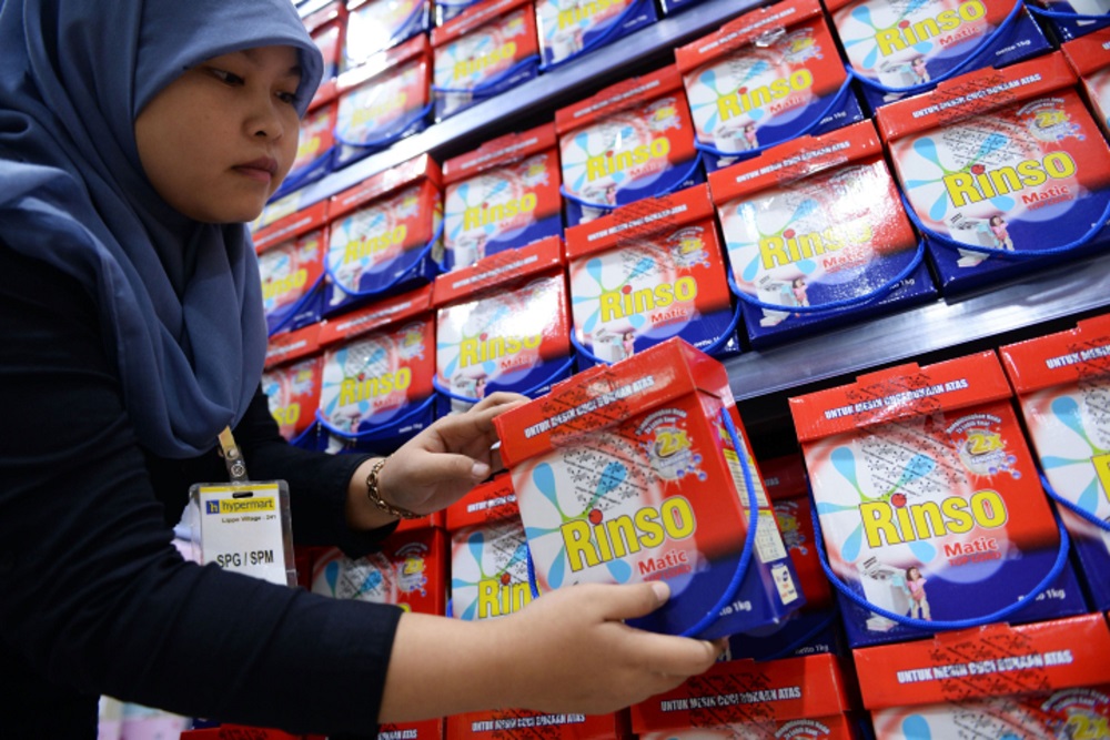 Seorang karyawan Hypermart di Karawaci, Banten menata deterjen laundry Rinso milik Unilever./Bloomberg-Dimas Ardian