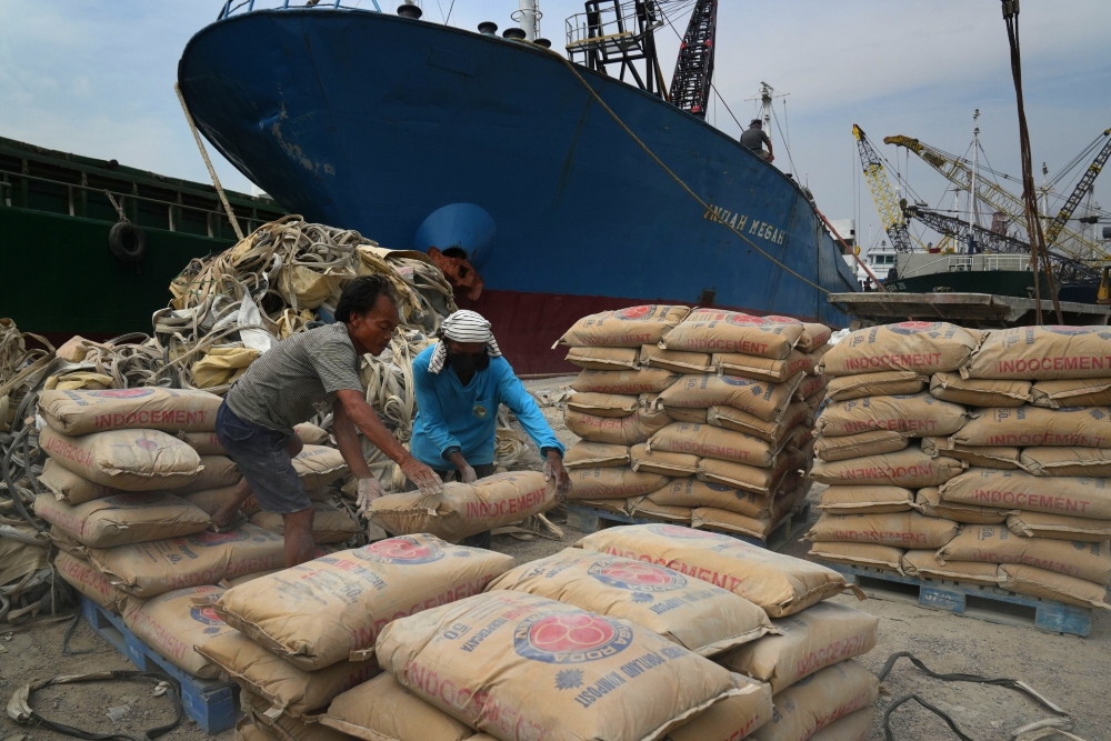 Pekerja mengangkut semen ke kapal pengangkutan di Pelabuhan Sunda Kelapa, Jakarta, Senin (11/7/2023). Bloomberg/Dimas Ardian