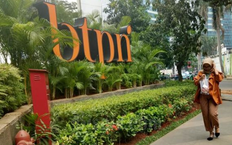 Pejalan kaki melintas di dekat logo PT Bank Tabungan Pensiunan Nasional Tbk. di Jakarta, Selasa (16/10/2018)./JIBI-Dedi Gunawan