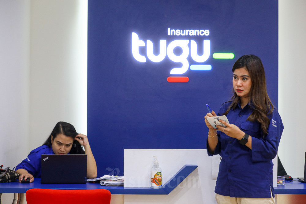 Karyawati beraktivitas di dekat logo Tugu Insurance, Jakarta, Senin (18/9/2023). Bisnis/Abdurachman