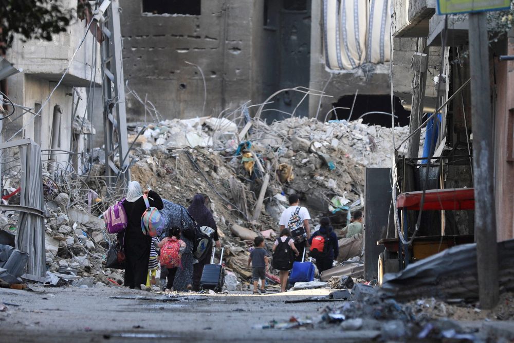 Warga Palestina membawa barang-barang mereka saat meninggalkan rumah mereka, di tengah konflik yang sedang berlangsung antara Israel dan kelompok Islam Palestina Hamas, di Kota Gaza 7 November 2023. REUTERS/Mohammed Al-Masri