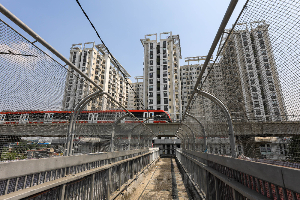 Kereta LRT Jabodebek melintas di dekat apartemen berorientasi TOD di Jakarta, Selasa (5/9/2023). Bisnis/Himawan L Nugraha