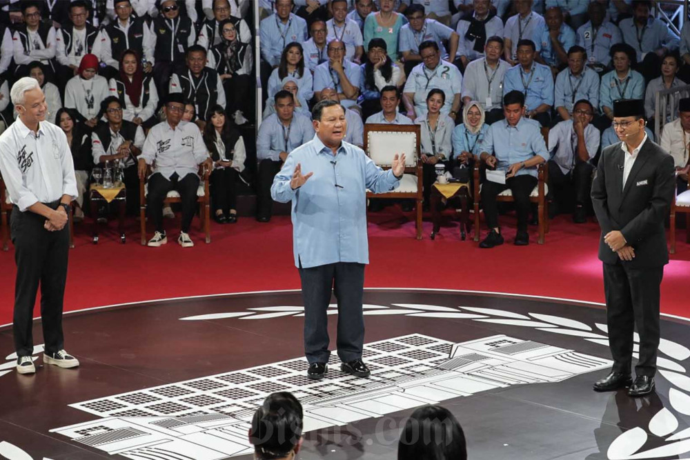 Calon Presiden nomor urut 1 Anies Baswedan (kanan), Calon presiden nomor urut 2 Prabowo Subiyanto (tengah), dan Calon presiden nomor urut 3 Ganjar Pranowo saat Debat Capres Perdana di Jakarta, Selasa (12/12/2023). Komisi Pemilihan Umum (KPU) menggelar debat capres perdana dengan mengusung tema pemerintahan, hukum, HAM, pemberantasan korupsi, penguatan demokrasi, peningkatan layanan publik, dan kerukunan warga. Bisnis/Fanny Kusumawardhani