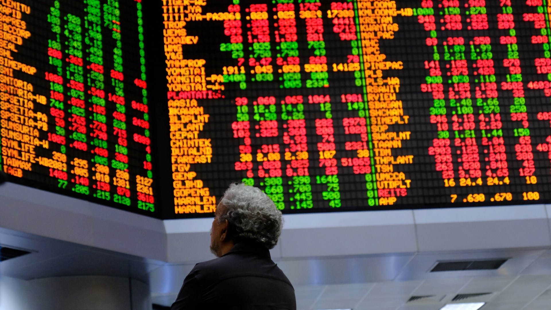 Seseorang melihat papan harga saham yang ditampilkan di galeri perdagangan RHB Investment Bank Bhd. di Kuala Lumpur, Malaysia pada Selasa (17/2/2020). - Bloomberg/Samsul Said