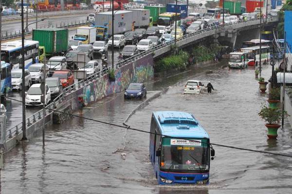 Busway menerobos genangan air di Grogol, Jakarta, Selasa (21/2)./JIBI-Abdullah Azzam
