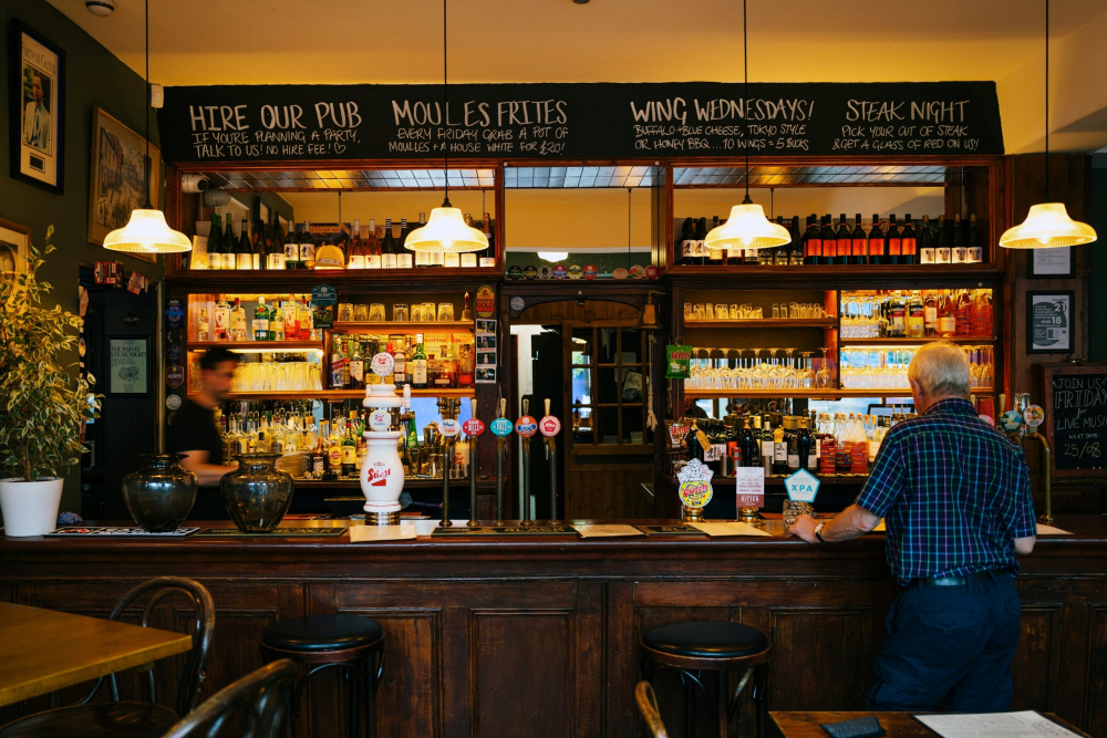 Suasana salah satu bar di London, Inggris pada Senin (14/8/2023). UU HKPD menetapkan bahwa diskotek, karaoke, kelab malam, bar, dan mandi uap/spa dikenakan pajak hiburan dengan tarif mulai dari 40% hingga 75%. - Bloomberg/Jose Sarmento Matos