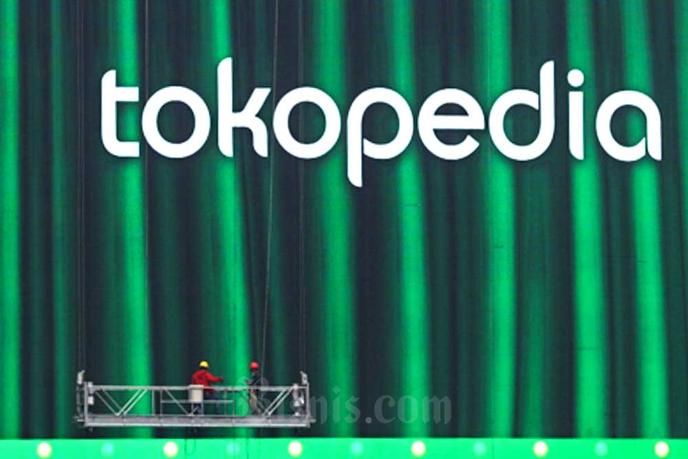 Pekerja melakukan perawatan videotron yang menampilkan iklan Tokopedia di Jakarta, Selasa (11/10/2022). Bisnis/Himawan L Nugraha