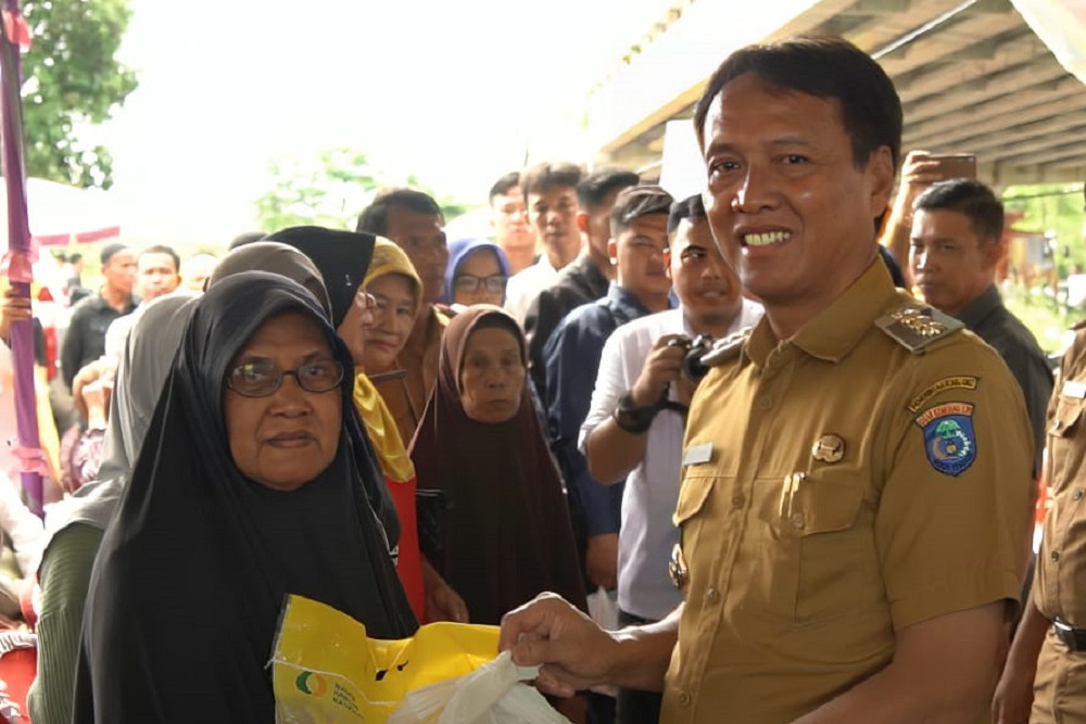 Pj. Bupati OKI Asmar Wijaya (kanan) menghadiri pasar murah di Desa Arisan Buntal Kecamatan Kayuagung, Senin (5/2/2024)./Istimewa